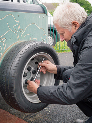 A playground inspector inspects playground springer wheel.